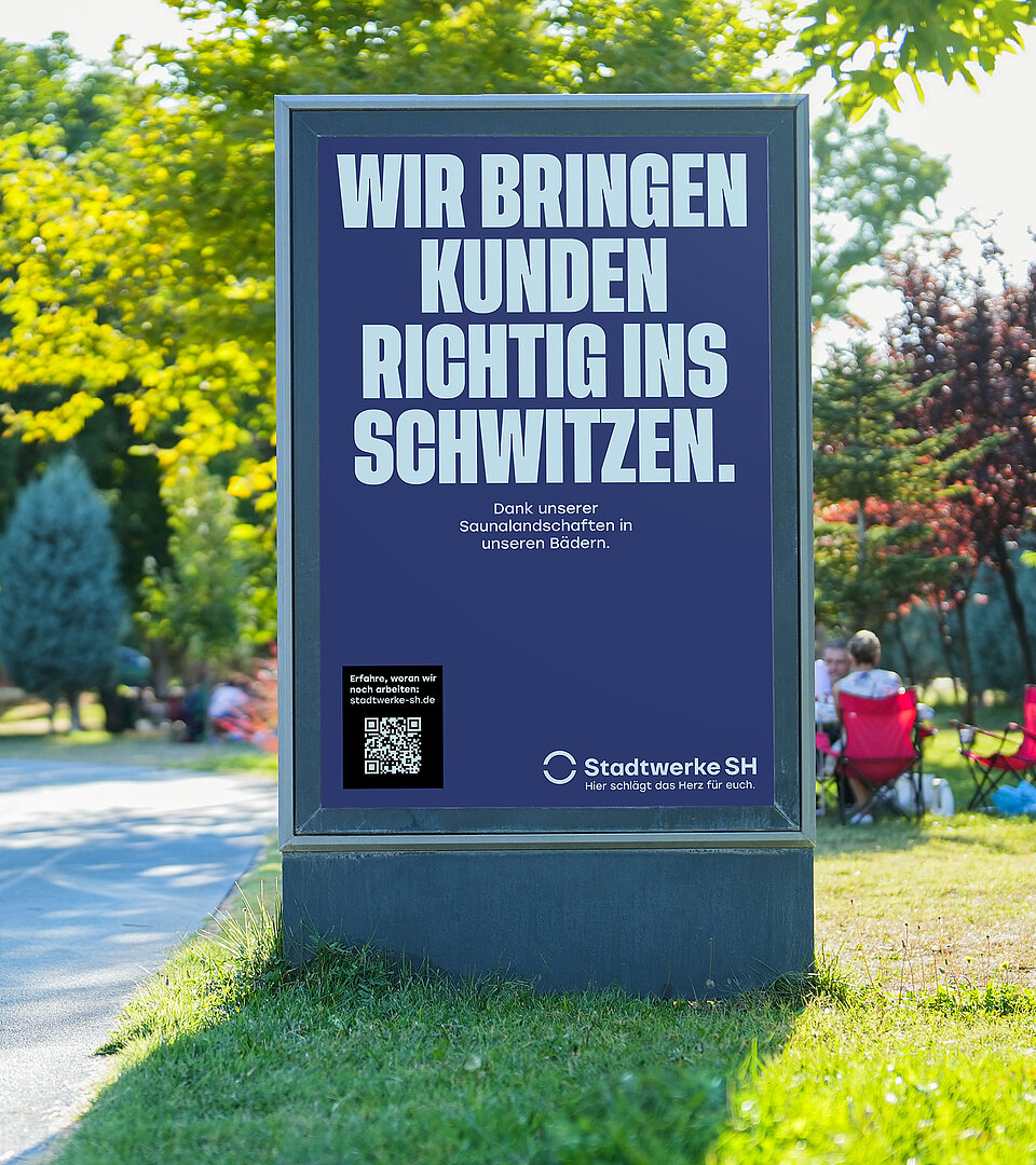 Hier sieht man eine Plakatstele mit Werbeplakat der Stadtwerke SH im Umfeld eines Stadtparks mit mehreren Personen.