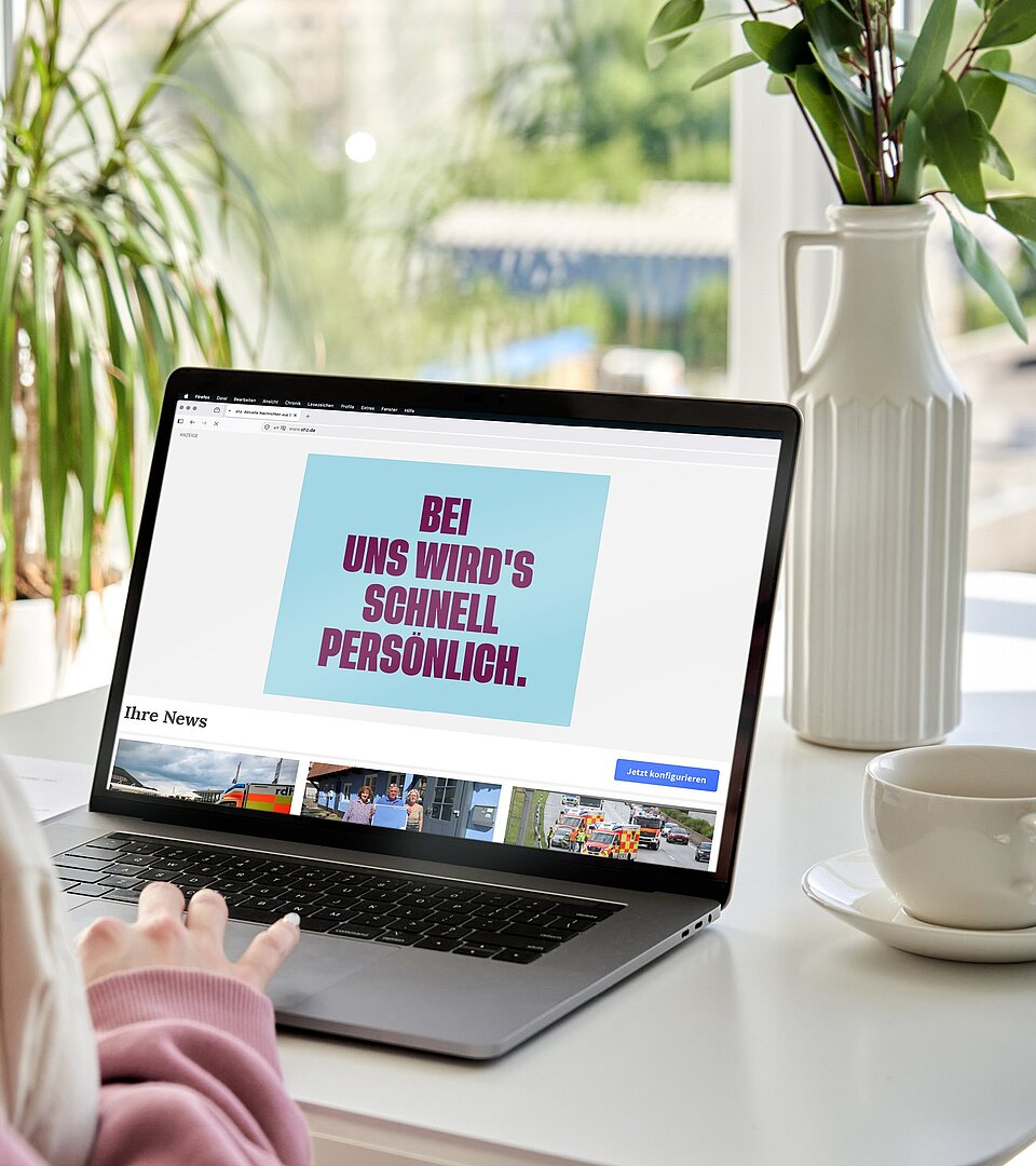 Person sitzt vor Laptop und scrollt auf einer Website mit angezeigter Werbeanzeige der Stadtwerke SH.